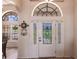 Elegant front door with decorative glass and side panels, complemented by an arched window at 12676 Bacchus Rd, Port Charlotte, FL 33981