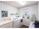 Bright laundry room with a window, utility sink, washer, and dryer at 12676 Bacchus Rd, Port Charlotte, FL 33981