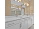 Bathroom featuring a double vanity with white cabinetry, granite countertops, and brushed gold faucets at 1352 Raspberry Dr, North Port, FL 34289