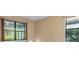 Neutral bedroom featuring two windows with natural light and views of outside greenery at 1352 Raspberry Dr, North Port, FL 34289