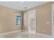 Neutral bedroom featuring tile floors, a window with natural light, and an ensuite bathroom at 1352 Raspberry Dr, North Port, FL 34289