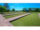Outdoor community bocce ball court near pond and a shaded seating area on a sunny day at 1352 Raspberry Dr, North Port, FL 34289