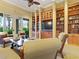 Elegant clubhouse library with bookshelves and comfortable seating with views of palm trees at 1352 Raspberry Dr, North Port, FL 34289