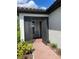 Screened entryway with brick flooring and view into a neutrally painted foyer at 1352 Raspberry Dr, North Port, FL 34289