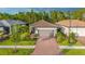 Charming home with manicured landscaping and a brick driveway leading to a two-car garage at 1352 Raspberry Dr, North Port, FL 34289