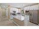 Modern kitchen with white cabinets, an island, stainless steel appliances, and beautiful tile backsplash at 1352 Raspberry Dr, North Port, FL 34289