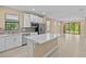 Modern kitchen with white cabinets, stainless steel appliances, and an island with a quartz countertop at 1352 Raspberry Dr, North Port, FL 34289