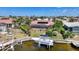Aerial view of a home with a screened pool, boat lift, and lush landscaping, showcasing prime waterfront living at 1425 Appian Dr, Punta Gorda, FL 33950