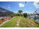 Lush backyard featuring a stepping stone path, mature landscaping, and a screened pool area near the canal and dock at 1425 Appian Dr, Punta Gorda, FL 33950