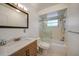 Bright bathroom featuring white cabinets, a walk-in shower, and tiled walls at 1425 Appian Dr, Punta Gorda, FL 33950