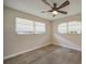 Bright bedroom with two windows and neutral walls, ceiling fan and light-colored floors at 1425 Appian Dr, Punta Gorda, FL 33950