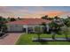 Charming single-story home with a red tile roof, well-manicured lawn, and tropical landscaping at 1425 Appian Dr, Punta Gorda, FL 33950