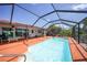 Outdoor screened pool area with tile deck and a view of lush landscaping at 1425 Appian Dr, Punta Gorda, FL 33950