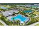 Beautiful aerial view of community amenities, including a pool, clubhouse, and tennis courts at 1490 Mableton Dr, Port Charlotte, FL 33953