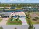 Aerial view of a blue single-Gathering house with a large manicured lawn and canal views at 15618 Aqua Cir, Port Charlotte, FL 33981