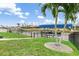 Waterfront backyard with a covered boat lift, green grass and tropical landscaping at 15618 Aqua Cir, Port Charlotte, FL 33981