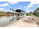 Patio with a covered boat dock, lift, and sun loungers at 15618 Aqua Cir, Port Charlotte, FL 33981