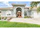 Inviting home entrance with double doors, arched windows, and well-manicured landscaping at 15618 Aqua Cir, Port Charlotte, FL 33981