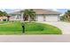 Charming single-story home featuring a spacious lawn, two-car garage, and a beautifully tiled roof at 15618 Aqua Cir, Port Charlotte, FL 33981