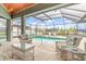 Enclosed lanai featuring a pool, hot tub, and comfortable wicker seating at 15618 Aqua Cir, Port Charlotte, FL 33981