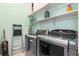 Modern laundry room with washer and dryer, shelving, and plenty of space for laundry tasks at 15618 Aqua Cir, Port Charlotte, FL 33981