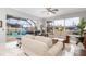 Open-concept living room with tile floors, comfortable seating, views of the pool, and natural light at 15618 Aqua Cir, Port Charlotte, FL 33981