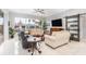 Bright living room with large windows, tile floors, comfortable seating, and a ceiling fan at 15618 Aqua Cir, Port Charlotte, FL 33981