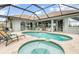 Beautiful screened-in pool and spa with travertine tile deck at 15618 Aqua Cir, Port Charlotte, FL 33981
