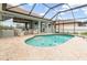 Lovely screened-in pool and spa with outdoor seating and travertine tile at 15618 Aqua Cir, Port Charlotte, FL 33981