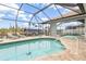 Inviting in-ground pool within a screened enclosure for outdoor enjoyment at 15618 Aqua Cir, Port Charlotte, FL 33981