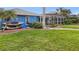 Spacious backyard with lush lawn, kayaks and a view of the pool enclosure for outdoor enjoyment at 17342 Foremost Ln, Port Charlotte, FL 33948
