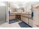 A primary bathroom with dual sinks, framed mirror, shower, floral wallpaper, and tile floors at 17342 Foremost Ln, Port Charlotte, FL 33948