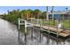 Boat lift and wooden dock on the canal, offering convenient waterfront amenities at 17342 Foremost Ln, Port Charlotte, FL 33948