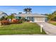Charming single-story home featuring a two-car garage, lush landscaping, and a well-manicured lawn at 17342 Foremost Ln, Port Charlotte, FL 33948