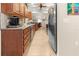 Galley kitchen features wood cabinets, granite counters, stainless steel appliances, and tile flooring at 17342 Foremost Ln, Port Charlotte, FL 33948
