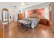 A primary bedroom showcases hardwood floors and a sitting bench in front of the bed at 17342 Foremost Ln, Port Charlotte, FL 33948