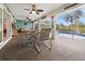 Inviting covered patio featuring ceiling fans, dining table, and access to screened-in pool area for outdoor relaxation at 17342 Foremost Ln, Port Charlotte, FL 33948