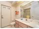 Bathroom showcasing a white vanity with sink, toilet, a shower stall, and bright lighting at 18379 Edgewater Dr, Port Charlotte, FL 33948