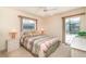 Cozy bedroom features a comfortable queen-sized bed, a ceiling fan, and a sliding door to the outside at 18379 Edgewater Dr, Port Charlotte, FL 33948
