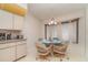 Cozy dining area featuring a round glass table, four wicker chairs, and a hanging light fixture at 18379 Edgewater Dr, Port Charlotte, FL 33948