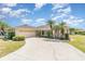 Attractive one-story home with an attached garage and beautiful landscaping including tropical palm trees and shrubs at 18379 Edgewater Dr, Port Charlotte, FL 33948