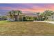 Charming one-story home featuring mature landscaping with palm trees and a well-maintained front yard at 18379 Edgewater Dr, Port Charlotte, FL 33948