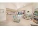 Open-concept living room with vaulted ceiling, neutral carpet, view of kitchen counter, and sliding glass doors to the backyard at 18379 Edgewater Dr, Port Charlotte, FL 33948