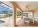 Covered outdoor patio with tile flooring, ceiling fan, a table with seating, and a pool at 18379 Edgewater Dr, Port Charlotte, FL 33948