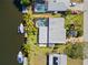 Aerial view of waterfront home with a private pool, boat dock, and beautiful landscaping at 18446 Burkholder Cir, Port Charlotte, FL 33948