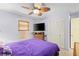 Bedroom featuring purple bedding, wicker furniture, and a ceiling fan at 18446 Burkholder Cir, Port Charlotte, FL 33948