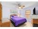 Bedroom featuring purple bedding, wicker furniture, and a ceiling fan at 18446 Burkholder Cir, Port Charlotte, FL 33948