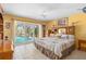 Bright bedroom with sliding glass doors to the pool area and ensuite bathroom at 18446 Burkholder Cir, Port Charlotte, FL 33948
