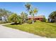 Home's curb appeal enhanced by lush landscaping and mature palm trees at 18446 Burkholder Cir, Port Charlotte, FL 33948