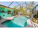 Backyard with covered pool area featuring screen enclosure and tropical surroundings at 18446 Burkholder Cir, Port Charlotte, FL 33948